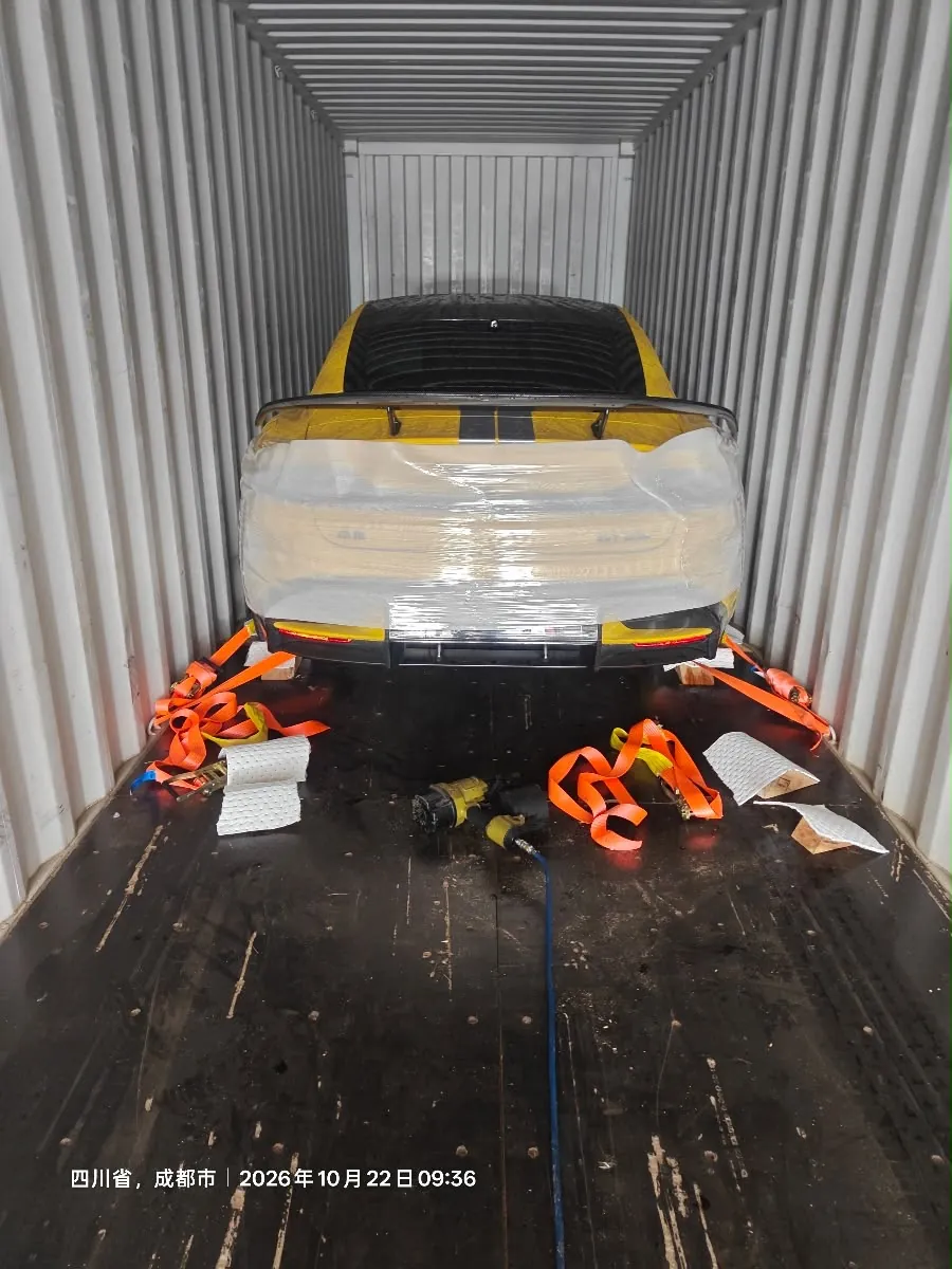 Eigenes Foto: der gelbe SU7 Ultra in Folie im Container, mit Spanngurten gesichert